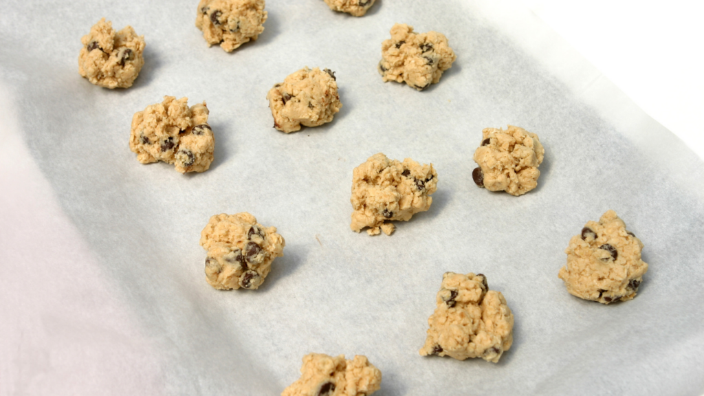 vegan cookie dough balls on a cookie sheet with parchment paper.
