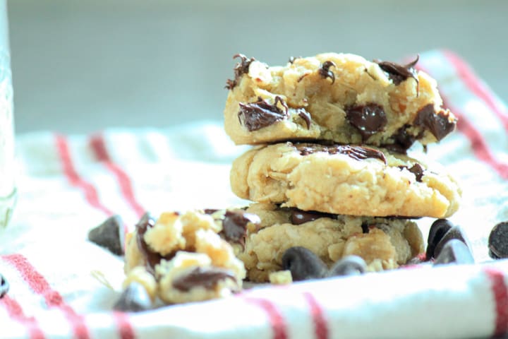 vegan oatmeal chocolate chip cookies 3 stacked high on a red and white dish towel.