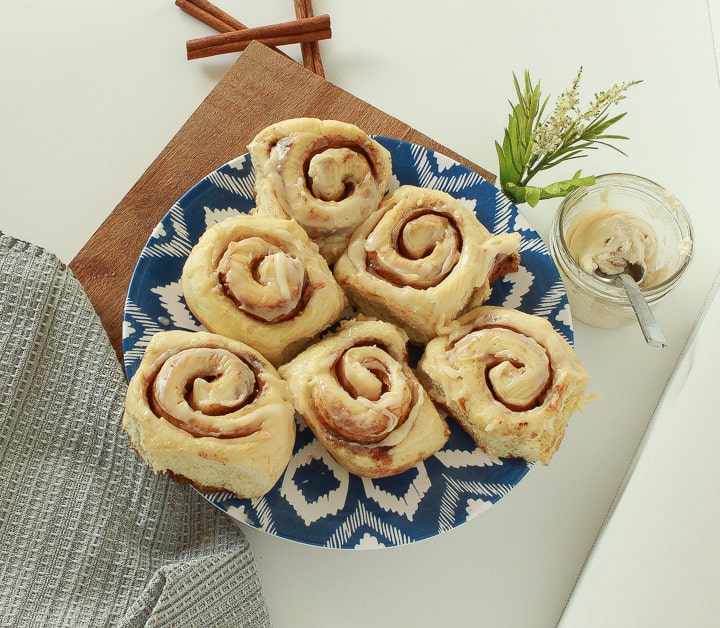 vegan cinnamon rolls in a triangle on a colorful blue and white plate. 