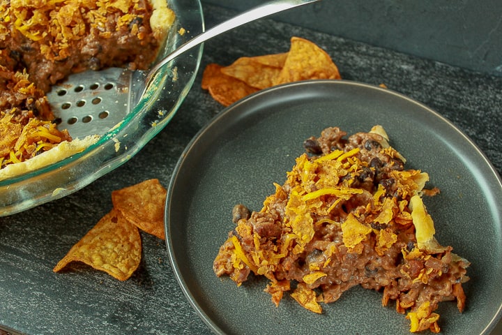 Amazing Vegan Taco Pie slice on a dark background. 