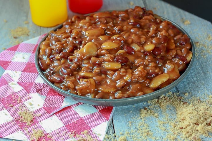 vegan calico beans in a large bowl on white wood. 