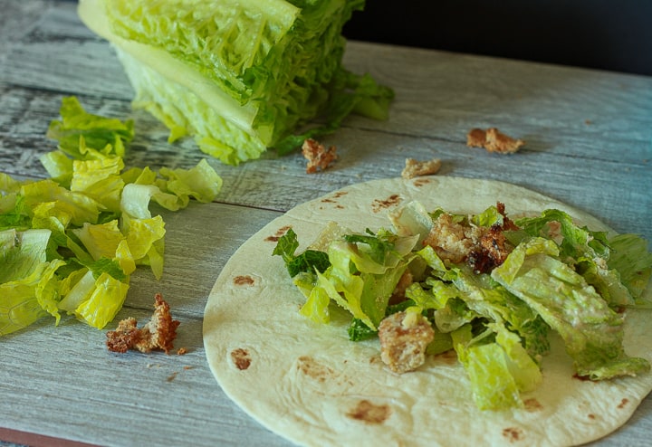 vegan salad mixture on a tortilla with lettuce in the background. 