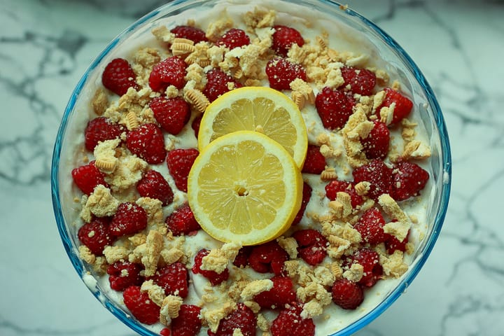 vegan trifle with two lemon slices on top on a marble background. 