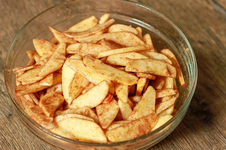 vegan cinnamon apples in a glass bowl. 