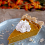 Single slice of vegan pumpkin pie on a blue plate.