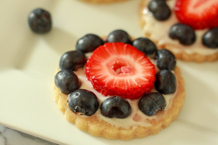 A single Vegan Dessert Pizza with fruit and blueberries on it on a white background. 