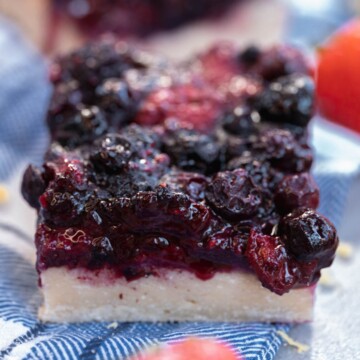One square of vegan berry bars on a blue and white checkered napkin close up shot.