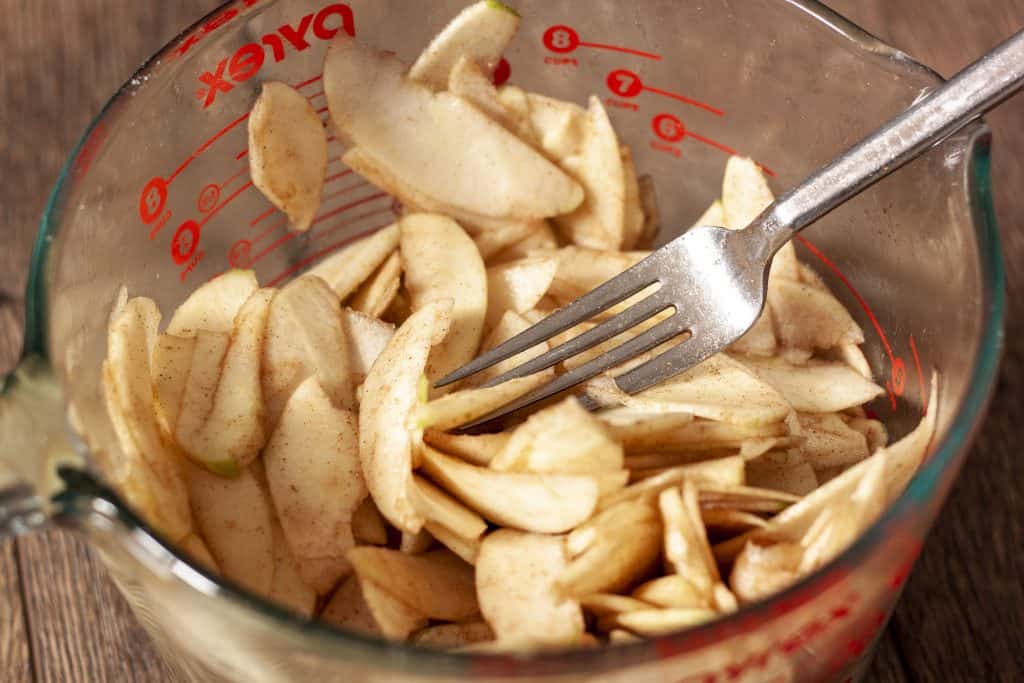 apple slices with cinnamon in a glass bowl. 