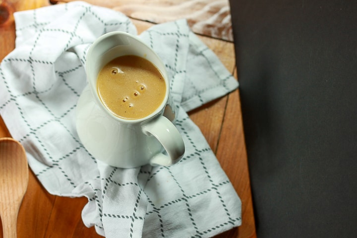 vegan gravy in a mug on a towel. 