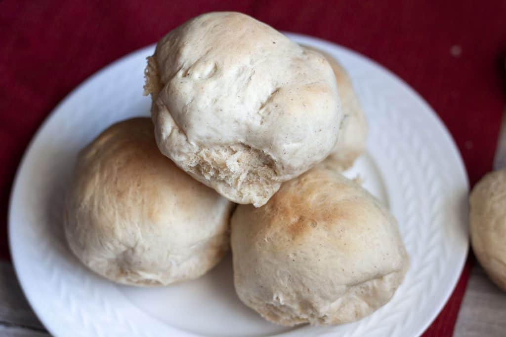 vegan oil free rolls piled on a white plate. 