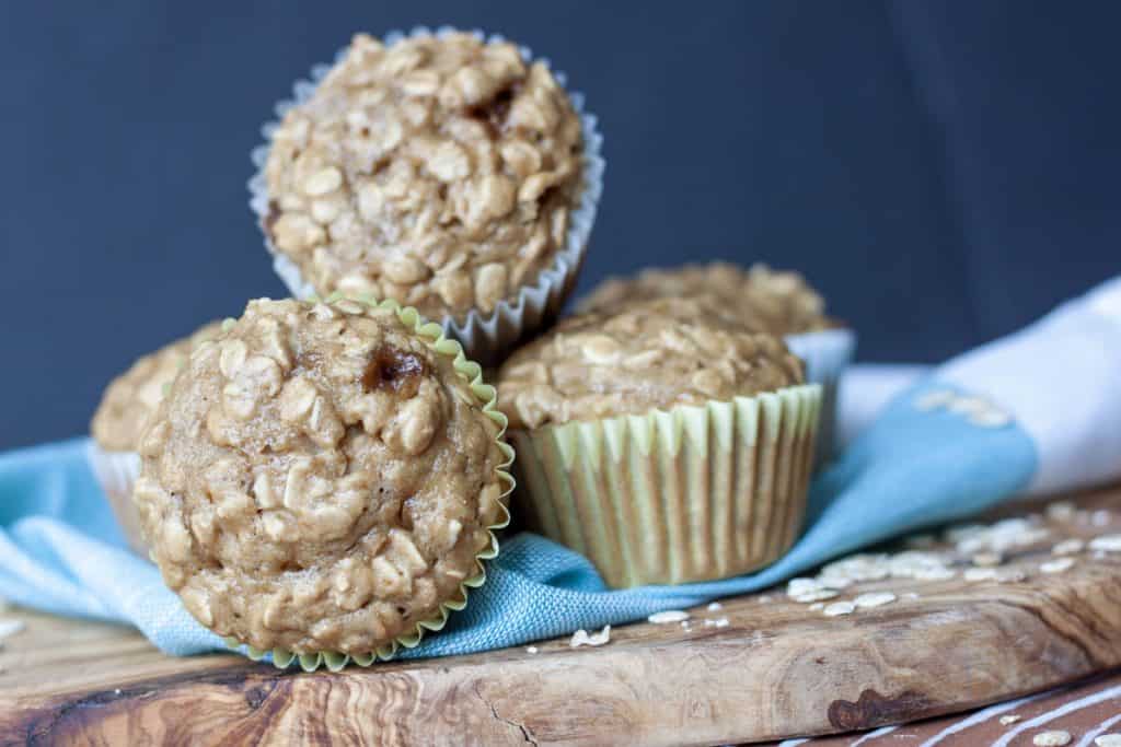 Vegan Oatmeal Muffins piled on eachother on a wood plate. 