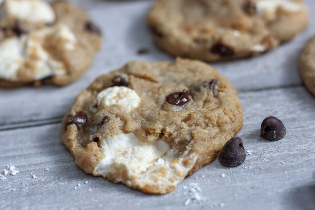 vegan smores cookies on a white wood background. 