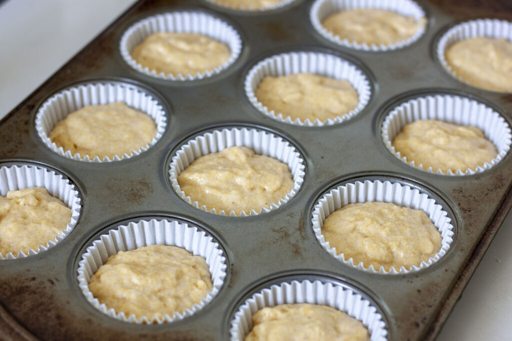 pre-cooked vegan corn muffins batter in the muffin tin. 