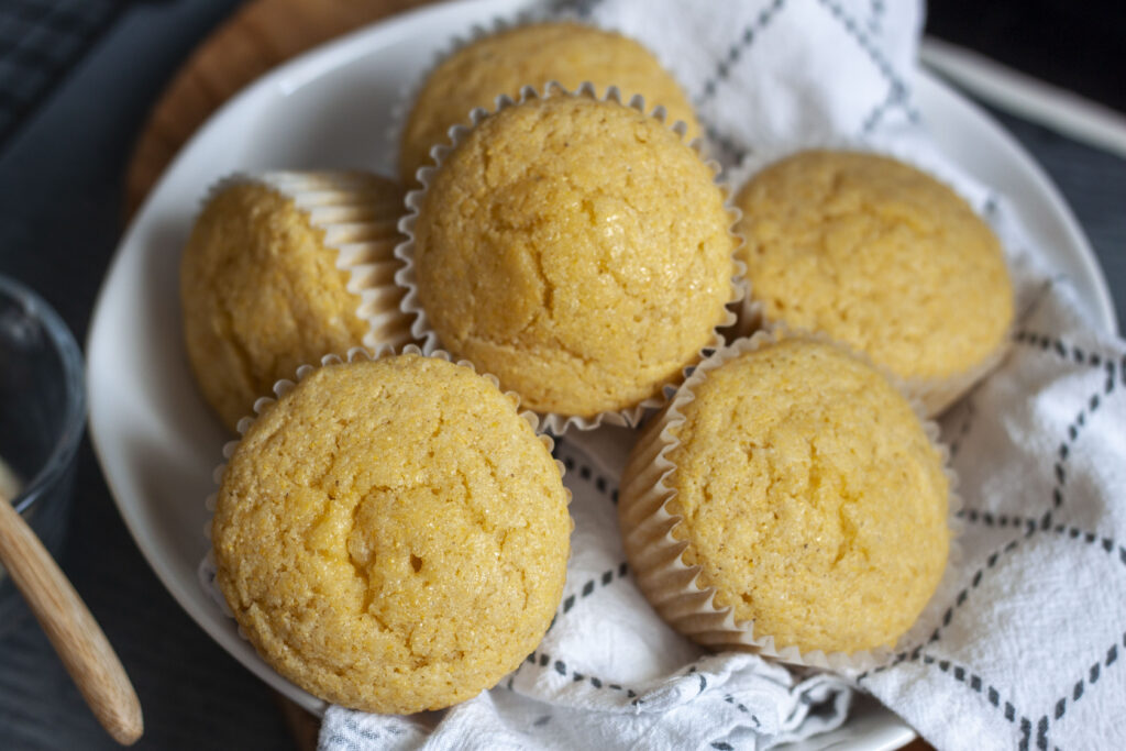 vegan corn muffins together in a bowl with a dish towel. 