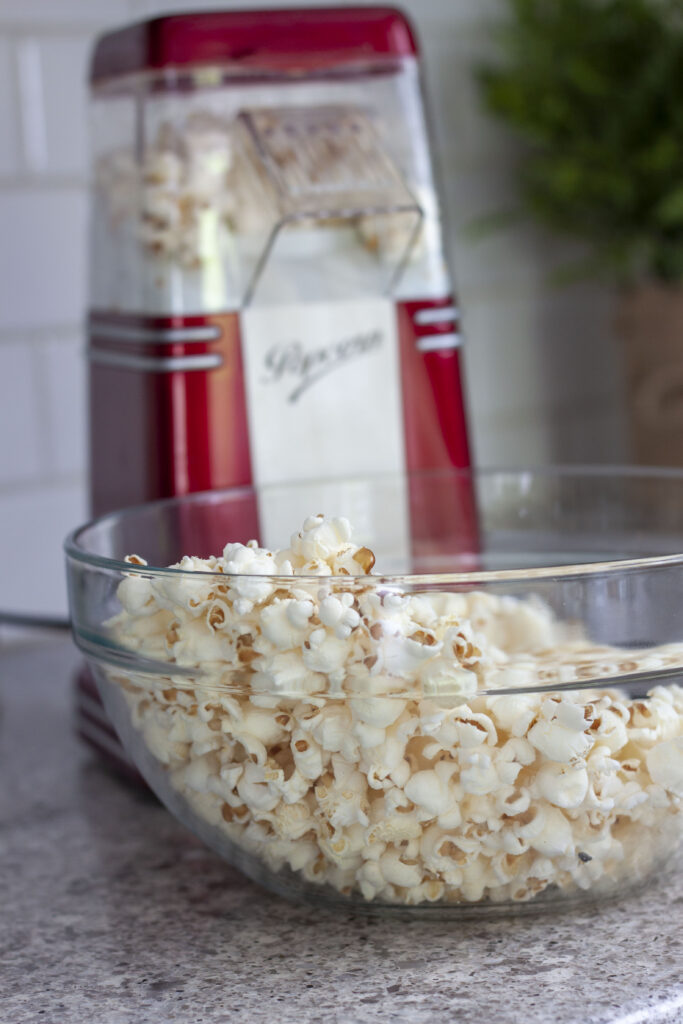 popping the popcorn into a glass bowl. 