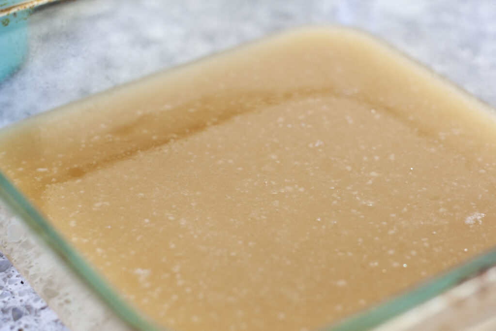vegan caramel cooling in a glass square container. 