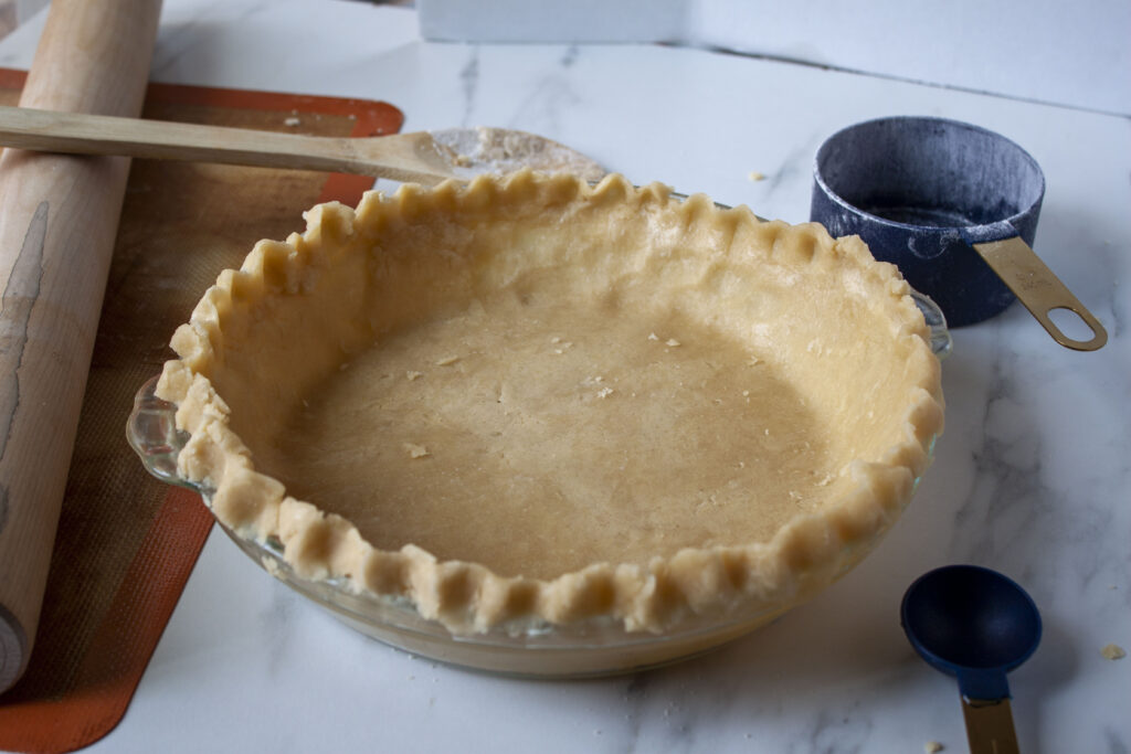 vegan pie crust in a glass pie pan with fluted edges. 