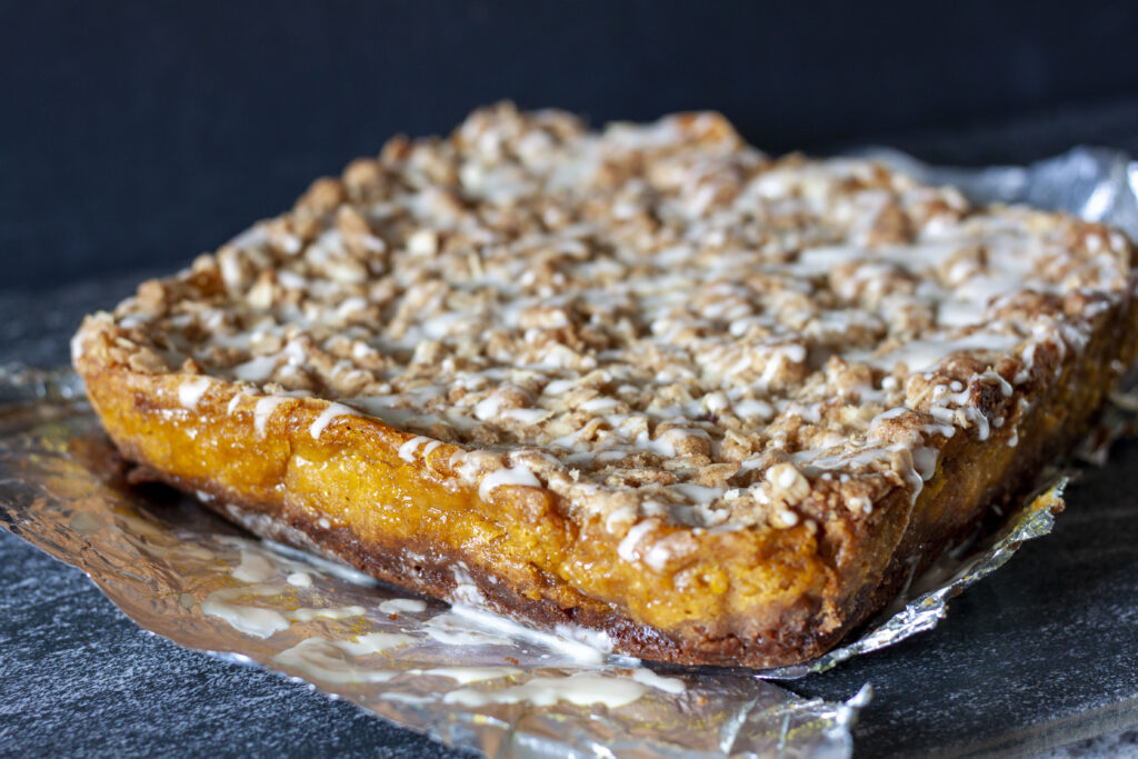 vegan pumpkin pie bar layers on a silver and black background.