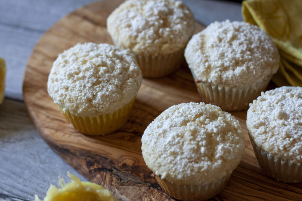 vegan lemon muffins 5 pictured on a wood background.