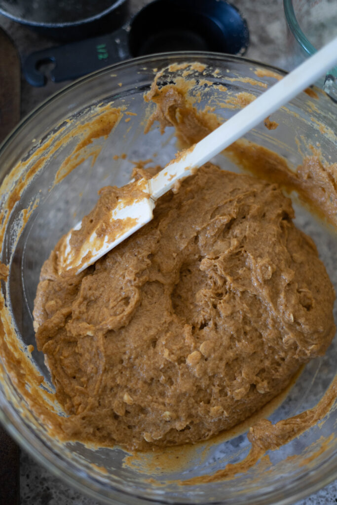 vegan pumpkin muffins batter all mixed in a bowl with a spatula. 