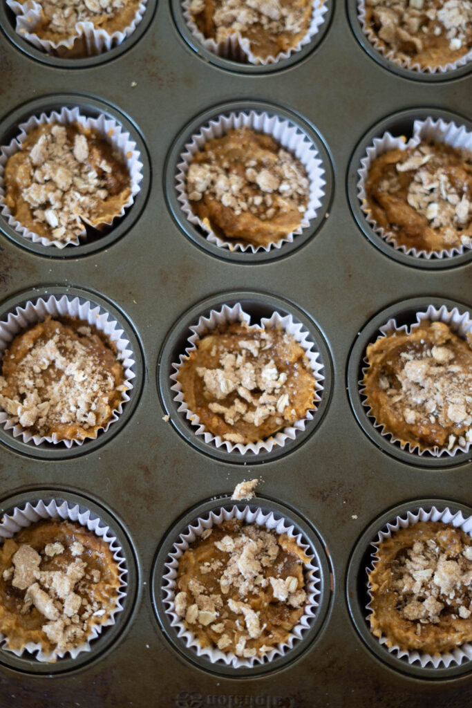 vegan crumb topping on the uncooked batter in a muffin tin.