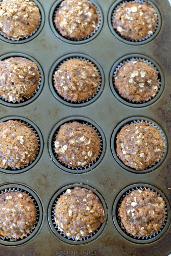 baked vegan pumpkin muffins in a muffin tin.