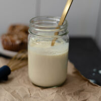 vegan buttermilk in a mason jar with a gold spoon.