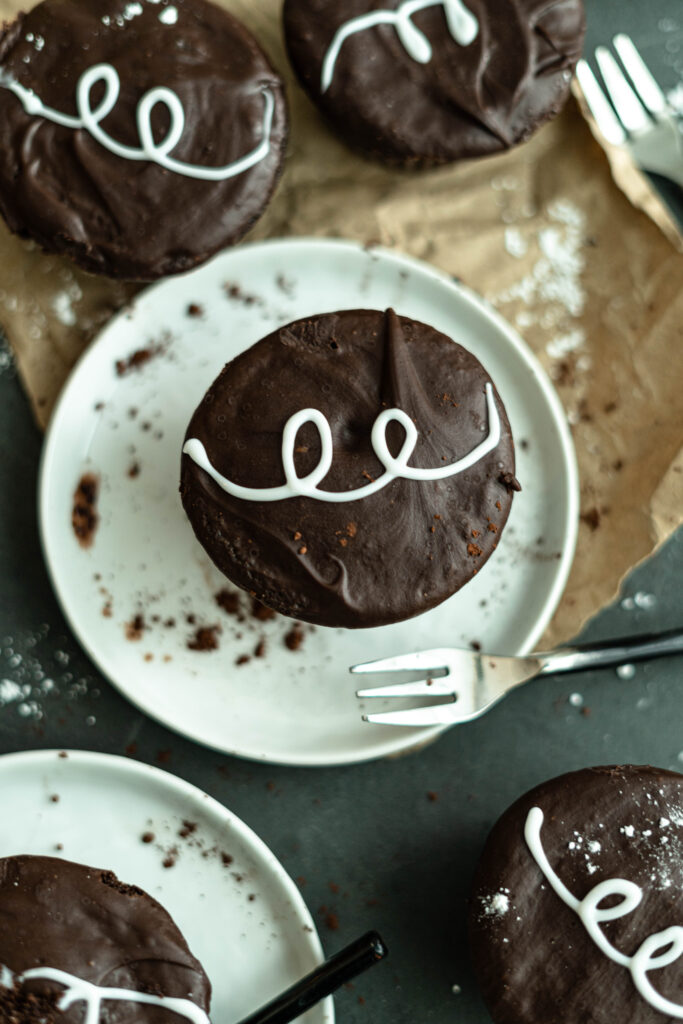 a single vegan hostess cupcakes on a white plate with a mini fork. 