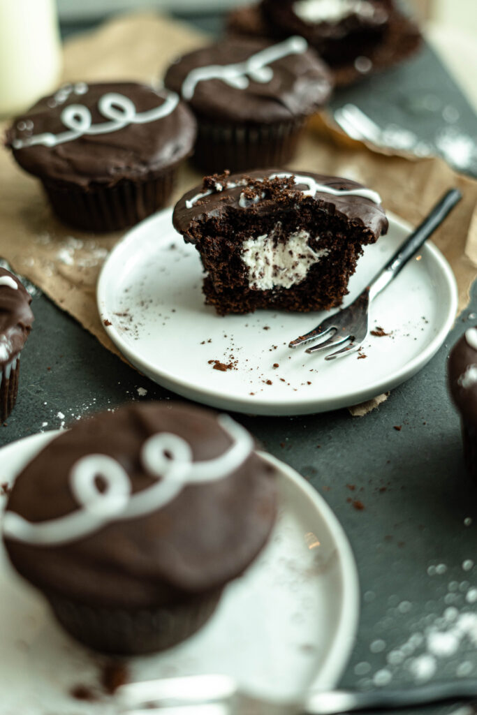 vegan hostess cupcake on a plate cut in half. 