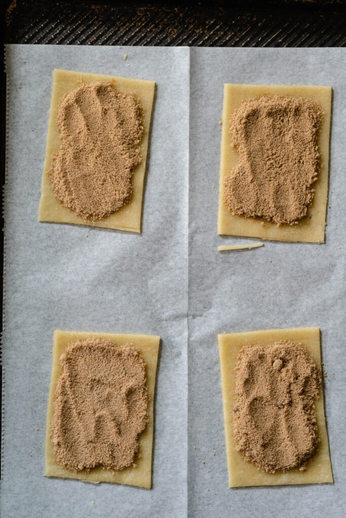 vegan pop tart brown sugar filling on 4 of the rectangles on a piece of parchment paper. 