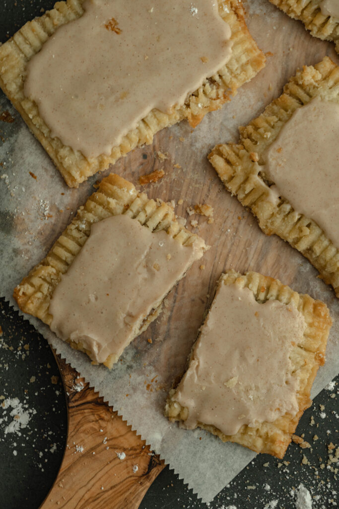 pop tart cuts on parchment paper on a wood background with one po[ tart cut in half. 