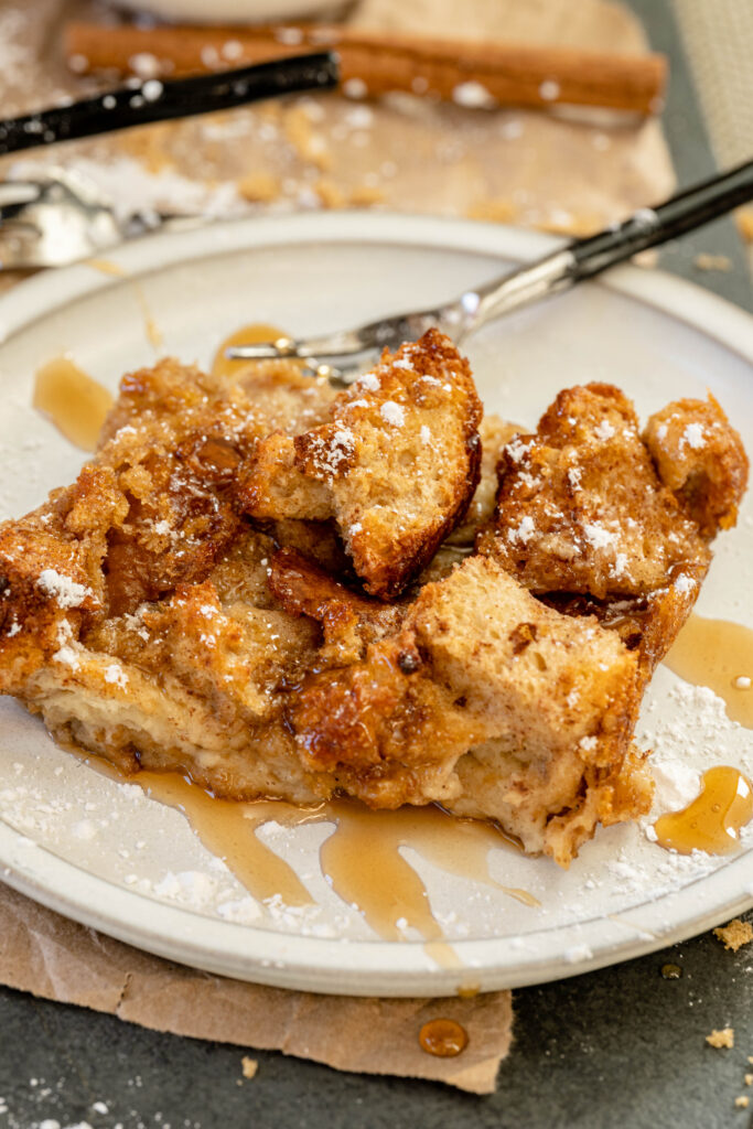 vegan french toast casserole on a white plate with syrup. 
