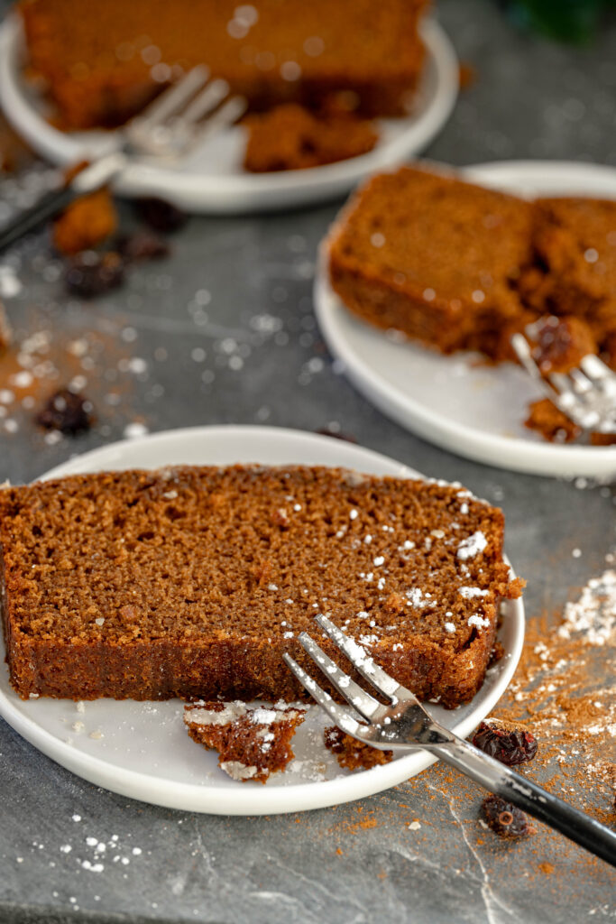 vegan gingerbread loaf slices on small white plates and little fork. 