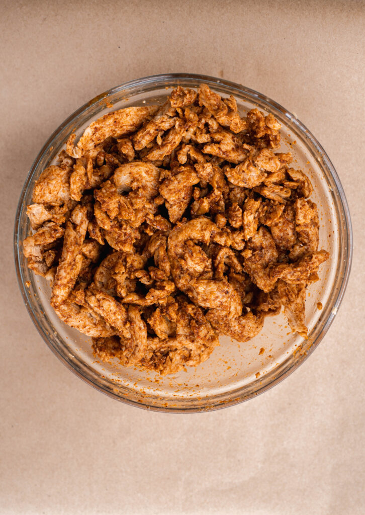 marinated soy curls in a glass bowl on a brown background. 