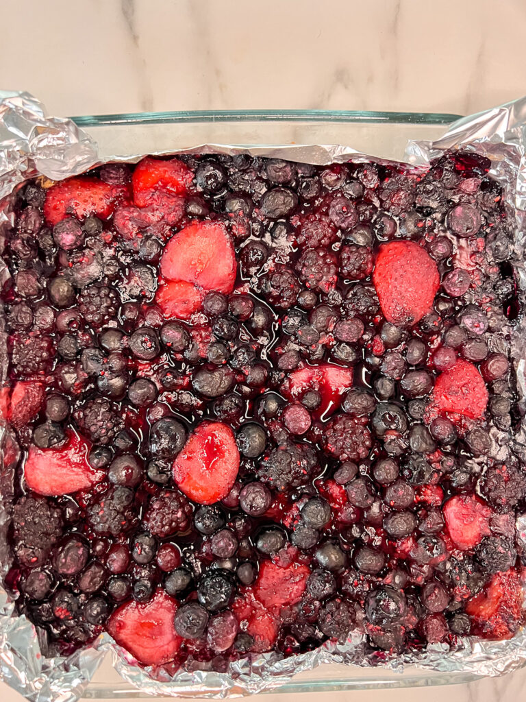 Fruit baked in an 8x8 glass pan with a foil overhang. 