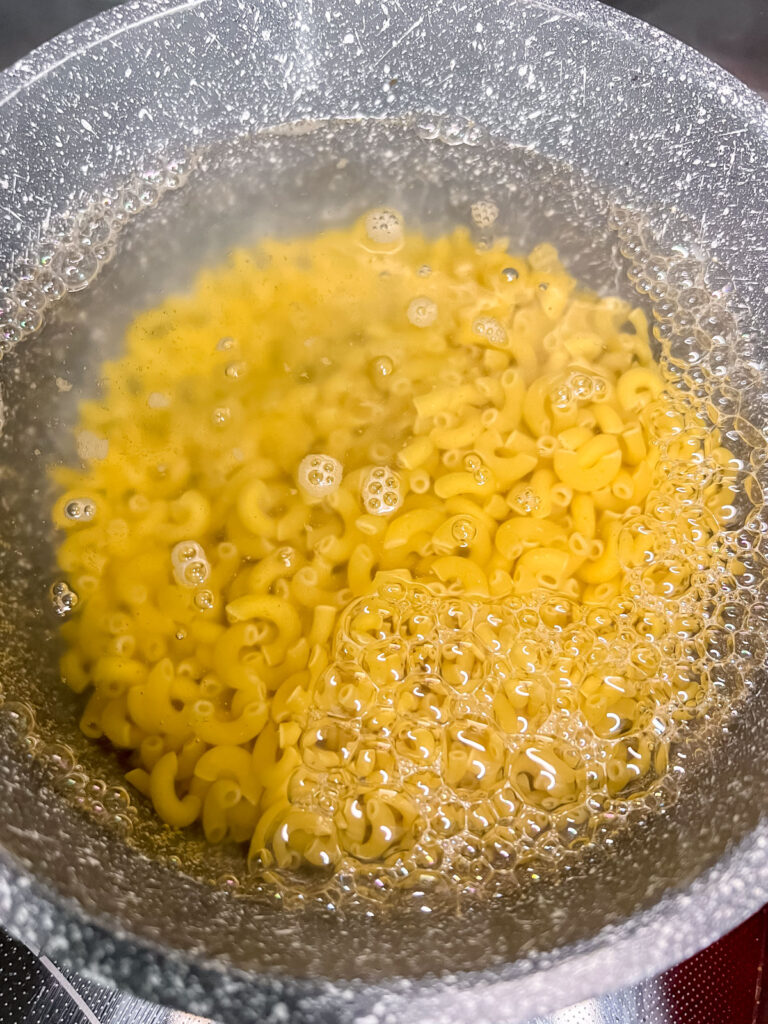Noodles cooking in boiling water in a pot.
