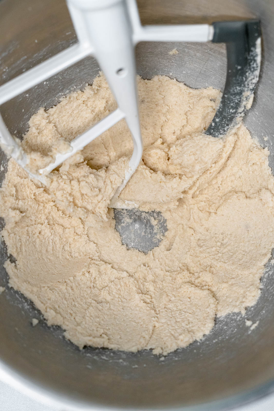 Creamed vegan butter and sugar in a silver mixing bowl with the paddle attachment. 