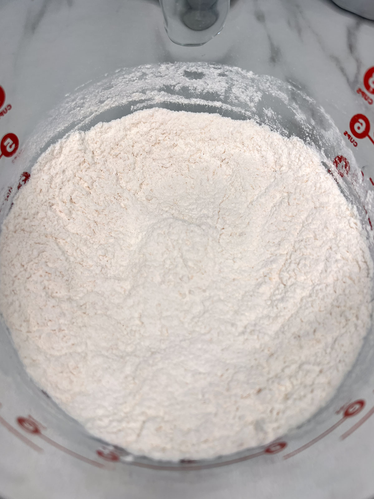 All the dry ingredients for the vegan shortcake in a glass bowl on a white background. 