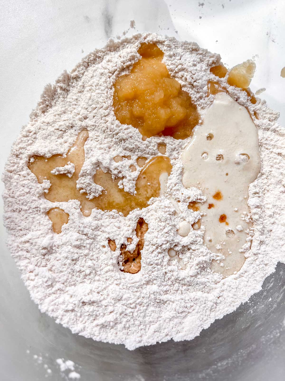 Vegan Apple Cider donuts with it's dry and wet ingredients in a clear bowl. 