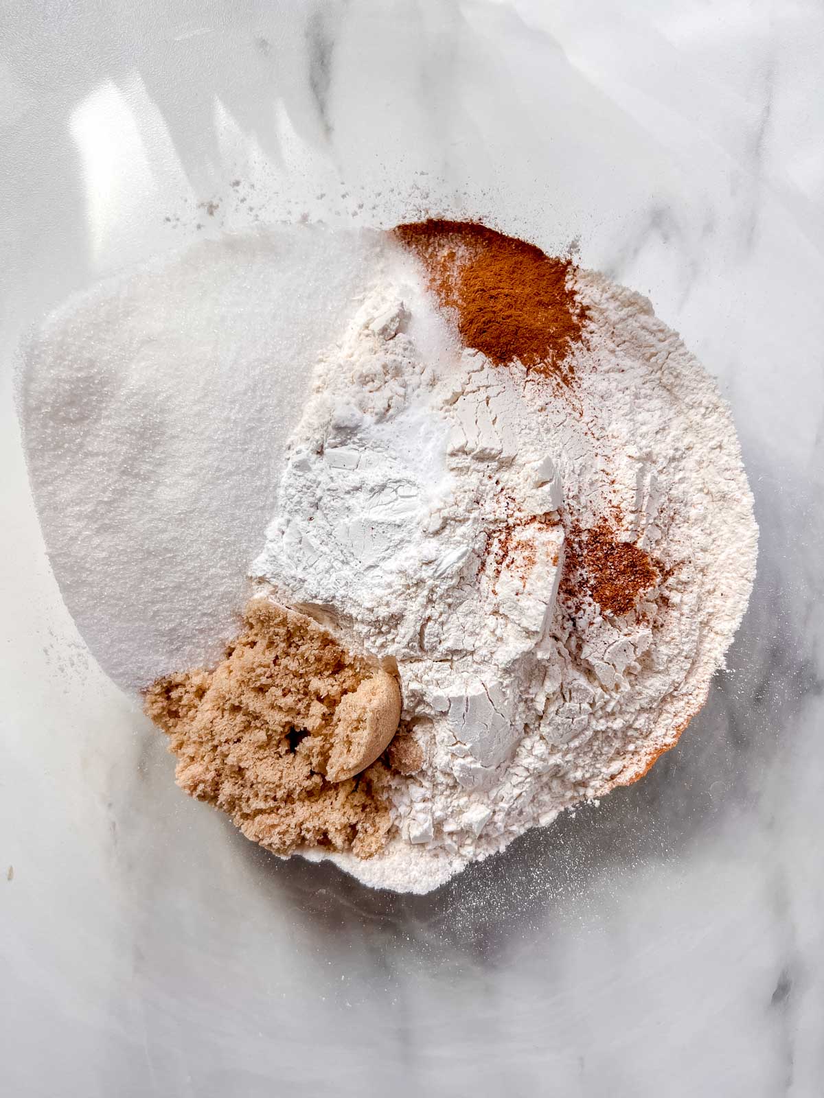 Vegan apple cider donuts dry ingredients in a clear bowl. 