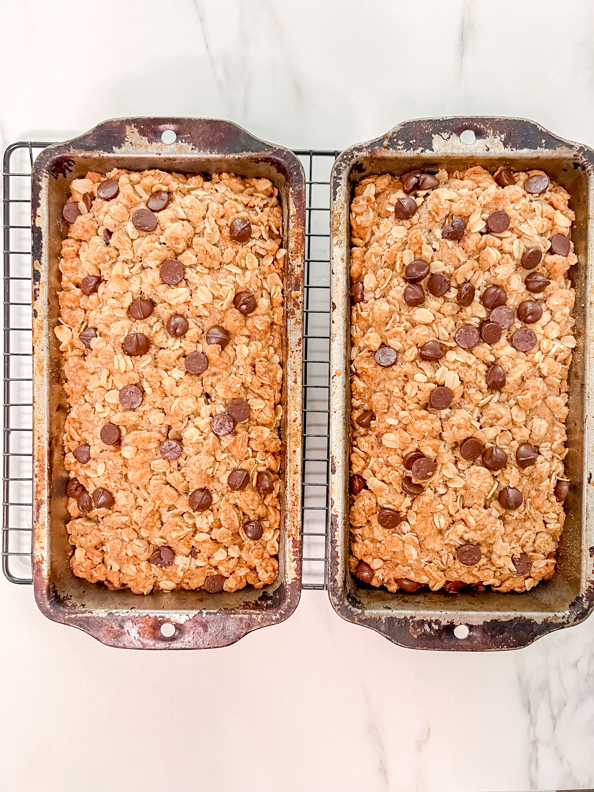 Cooked vegan zucchini bread in two loaf pans side by side. 
