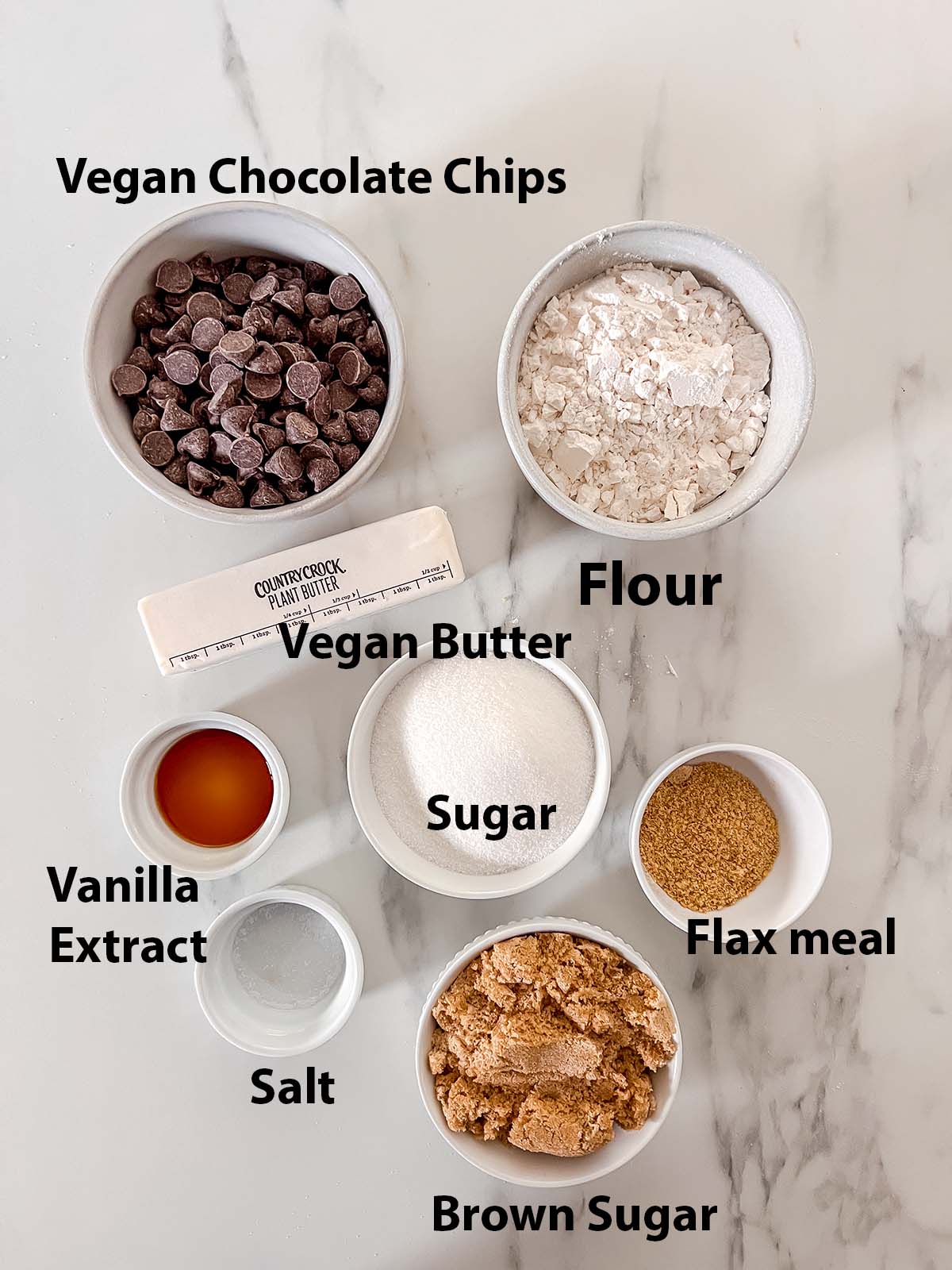 Vegan chocolate chip pie ingredients in small containers with black labels. 
