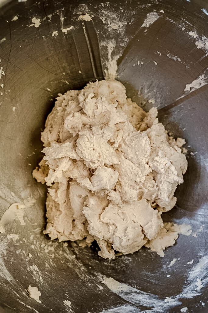 Cookie dough in a silver mixing bowl. 