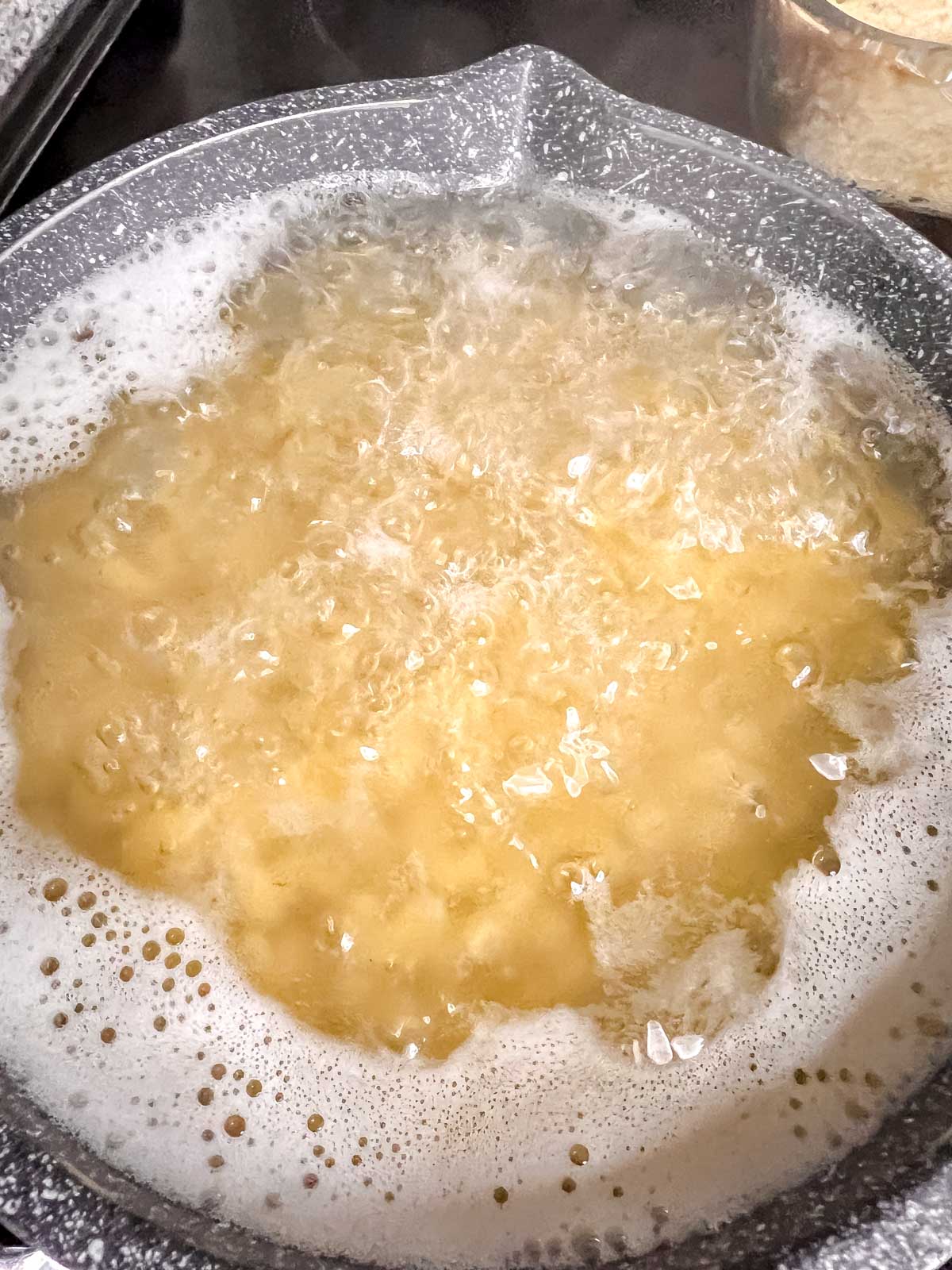 Macaroni noodles bowling in a grey pot. 